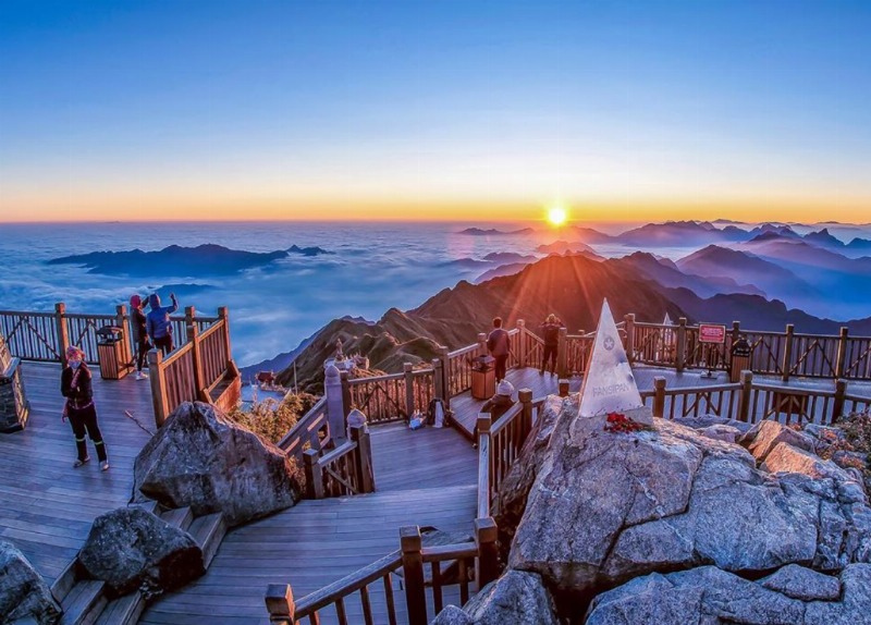 Một du khách đứng trên Cổng Trời 1 Núi Hàm Rồng Sapa, nhìn xuống thung lũng Mường Hoa rộng lớn với ruộng bậc thang và bản làng